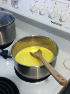 A stainless-steel pot on a stove, with a creamy yellow liquid