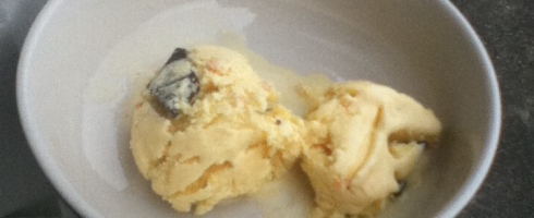 A small bowl of pale yellow ice cream - french vanilla colour - viewed from above.